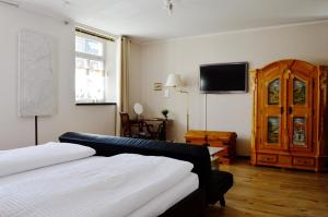 1 dormitorio con 2 camas y TV en la pared en Ferienwohnung Sesslach Altstadt, en Seßlach