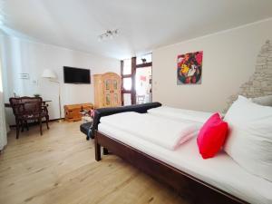 Schlafzimmer mit einem Bett mit weißer Bettwäsche und roten Kissen in der Unterkunft Ferienwohnung Sesslach Altstadt in Seßlach