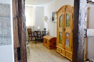 Zimmer mit einem großen Holzschrank und einem Tisch in der Unterkunft Ferienwohnung Sesslach Altstadt in Seßlach