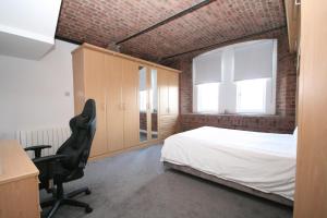 a bedroom with a bed and a desk and a chair at Waterloo warehouse in Liverpool
