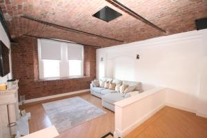 a living room with a couch and a brick wall at Waterloo warehouse in Liverpool