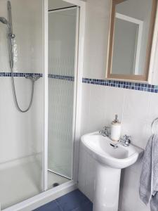 een witte badkamer met een wastafel en een douche bij Springmount Vacation 