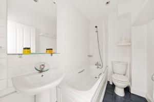 ロンドンにある1 & 2 Bed Cosy Apartments next to Earls Court FREE WIFIの白いバスルーム(洗面台、トイレ付)