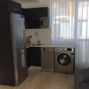 a kitchen with a refrigerator and a washing machine at Apartamentos Hostería de Boo in Boó de Piélagos