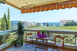 einen Tisch und Stühle auf einem Balkon mit Aussicht in der Unterkunft CASA MYRlAM Marousi -View & Private Parking- in Athen