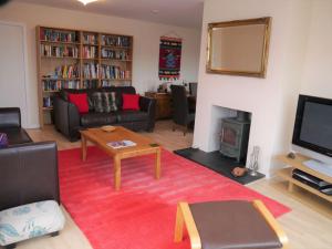 a living room with a couch and a tv at Arakhova in Kirkcudbright