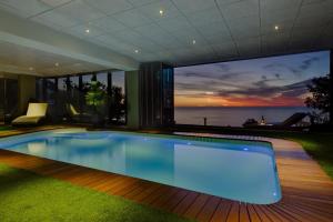 a swimming pool in a house with a view of the ocean at Atlantic Gold in Cape Town