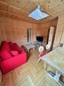 a living room with a red couch and a table at Appartamenti Mottini Plaza in Livigno