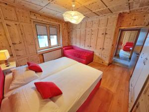 a bedroom with a large bed and a red couch at Appartamenti Mottini Plaza in Livigno