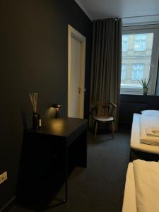 a hotel room with a bed and a desk and a window at Hotel Maritime in Copenhagen