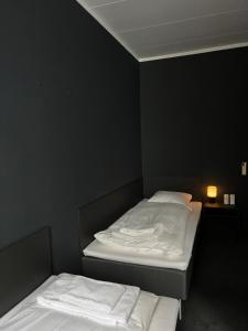 two twin beds in a room with black walls at Hotel Maritime in Copenhagen
