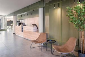 a lobby with two chairs and a counter at B&B HOTEL Lisboa Aeroporto in Lisbon