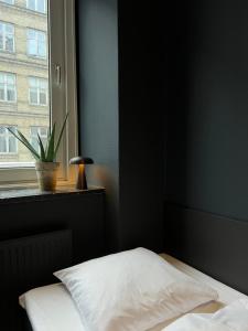 a bedroom with a bed and a window with a plant at Hotel Maritime in Copenhagen