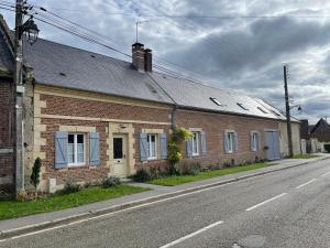 a brick building with blue windows on a street at Confortable duplex au cœur de la campagne Picarde à 1h de Paris in Biermont +11 photos