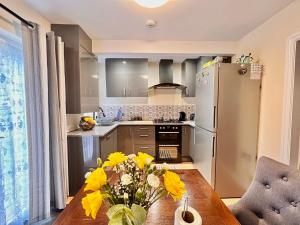 a kitchen with a wooden table and a refrigerator at Guest House Rooms Birmingham in Birmingham