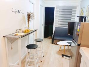 a small kitchen with a counter and stools in a room at Cabuhat Duco Lodge 2 in Naic