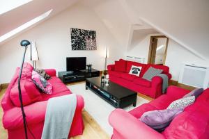 sala de estar con 2 sofás rojos y TV en Big Moo, en Llanrhyddlad