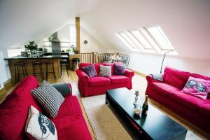 sala de estar con sofás rojos y cocina en Big Moo, en Llanrhyddlad