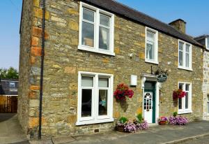 a stone building with flowers in front of it at The Tannochbrae in Dufftown