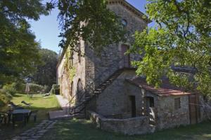 ein Steingebäude mit einer Treppe, einem Tisch und Stühlen in der Unterkunft Agriturismo Le Vigne di Pace in Umbertide