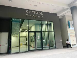 a person sitting in front of a building with a glass door at Jesselton Quay,2BR,4-5pax,Mountain view in Kota Kinabalu