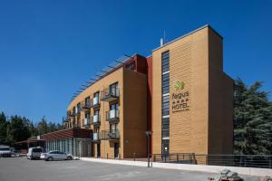 a hotel building with a car parked in front of it at Fagus Hotel Conference & Spa Superior in Sopron