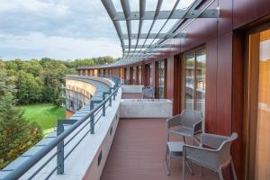 a balcony of a building with chairs and windows at Fagus Hotel Conference & Spa Superior in Sopron