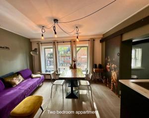 sala de estar con sofá púrpura y mesa en Appartementen in het centrum van Hoorn en Hoorn