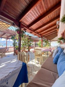 un patio con pergolato in legno, tavolo e sedie. di Grikos Hotel a Grikos