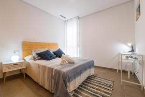 a bedroom with a large bed with a wooden headboard at Jardines Iro in Chiclana de la Frontera
