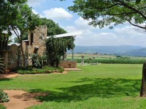 a stone building in the middle of a field at Malandela's Guest House in Malkerns