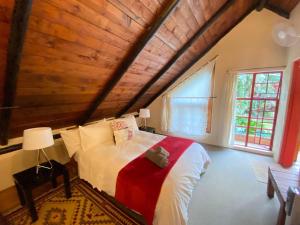 a bedroom with a large bed with a wooden ceiling at Malandela's Guest House in Malkerns