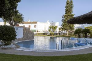 a large swimming pool in the middle of a park at Beautiful Duplex in Chiclana de la Frontera