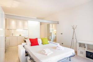 un letto bianco con cuscini colorati in una stanza di Padova Centre Cosy Apartment a Padova