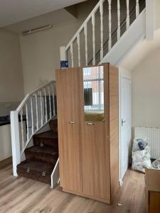 a staircase with a wooden cabinet next to a stair case at 1 Bedroom Flat - Milligan Road in Leicester