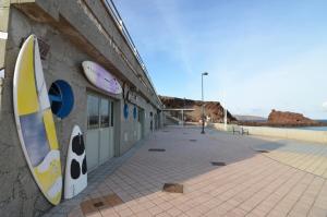 un edificio con tablas de surf pintadas en un lateral. en Aloha***Burrero cerca del Aeropuerto, en Playa del Burrero