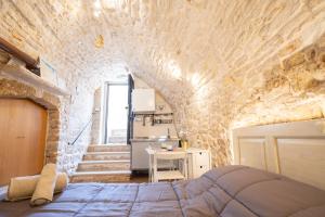 ジョヴィナッツォにあるPiccola Pietra Biancaの石壁のベッドルーム1室
