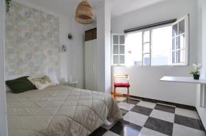 a bedroom with a bed and a checkered floor at Aloha***Burrero cerca del Aeropuerto in Playa del Burrero