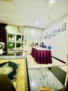 Habitación con mesa y mantel púrpura. en Paka Tamim Seaview Hotel en Paka