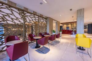 un restaurante con mesas y sillas coloridas en el vestíbulo en Avar Hotel, en Mátrafüred