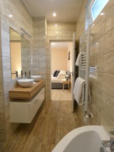 1 dormitorio y baño con bañera y lavamanos. en Milano Vendégház, en Bakonybél
