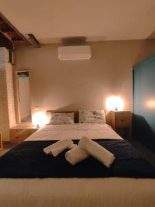 una camera da letto con un letto e due asciugamani di Loft il Chiostro della Cattedrale a Lucca