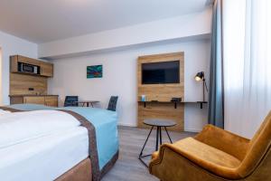 a hotel room with a bed and a chair at Trip Inn Hotel & Suites Essen in Essen +38 photos