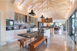 a large kitchen with a table and benches in it at Pezula Ocean Vista Luxury in Knysna