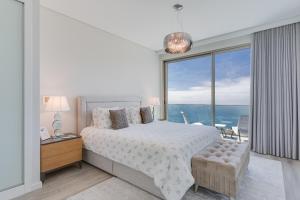 een slaapkamer met een bed en een groot raam bij Luxury Villa Bianca by Holiday Rental Madeira in Arco da Calheta +27 foto's
