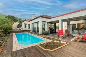 a house with a swimming pool on a wooden deck at Pezula Ocean Vista Luxury in Knysna