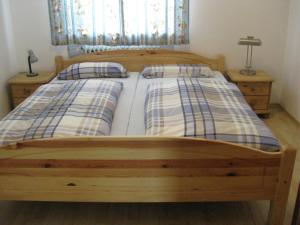 een houten bed met 2 kussens in een slaapkamer bij Sollingerhof in Teisendorf