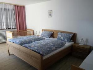 een slaapkamer met een bed met blauwe lakens en een raam bij Sollingerhof in Teisendorf