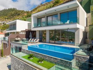 un'immagine di una casa con piscina di Luxury Villa Bianca by HR Madeira ad Arco da Calheta