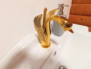 a bathroom sink with a gold sink faucet at Kaoglen Doe-Feature Bathroom-Cairngorms-Pets Allowed in Balnald +24 photos